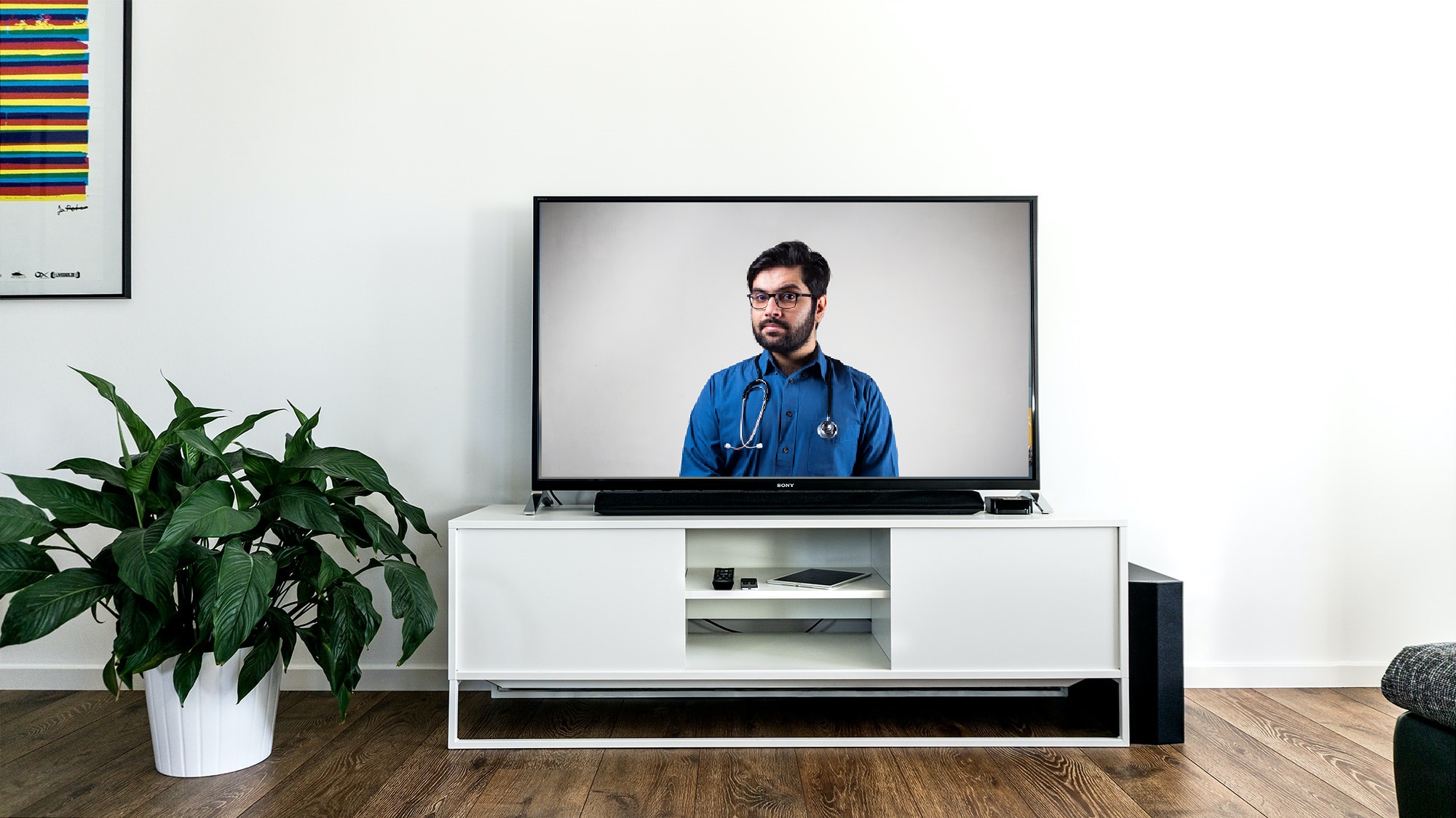 Televisie in een lichte woonkamer met een zorgverlener op het scherm